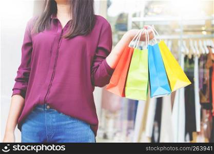 consumerism woman holding many shopping bags in fashion boutiqueafter buying presents ,enjoying sale and people concept
