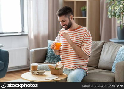 consumption, delivery and people concept - smiling man with takeaway food and drinks at home. smiling man with takeaway food and drinks at home