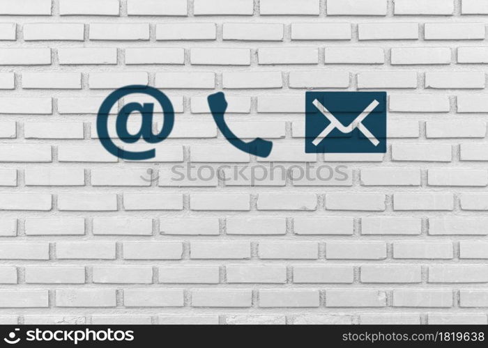 Contact Us. Phone, email and post icons paint on white brick wall