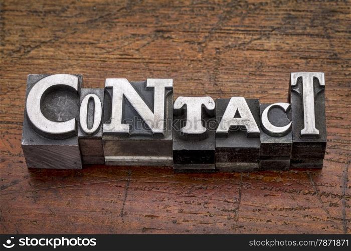 contact word in mixed vintage metal type printing blocks over grunge wood