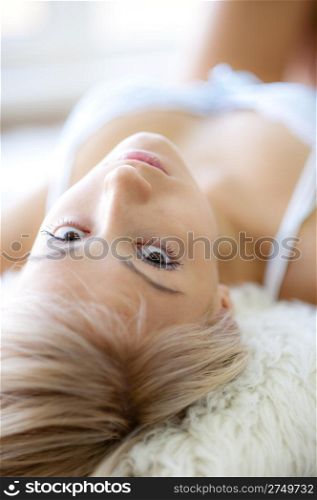 Contact. Young girl lying, looking at camera, natural light from window