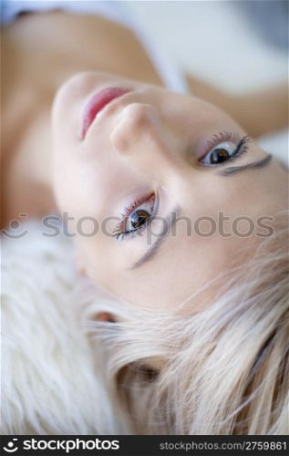 Contact. Young girl lying, looking at camera, natural light from window