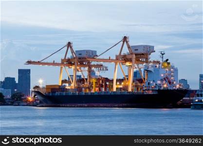 Container Cargo freight ship with working crane bridge in shipyard at evening for Logistic Import Export background