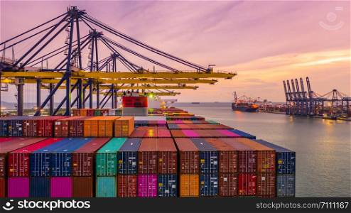 Container ship loading and unloading in deep sea port at sunset, Aerial view of business logistic import and export freight transportation by container ship in open sea.