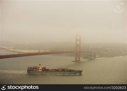 Container ship passing under a bridge, Golden Gate Bridge, San Francisco, California, USA