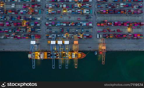 Container ship working at night, Business import export logistic and transportation of International by container ship in the open sea, Aerial view container ship loading and unloading at night.