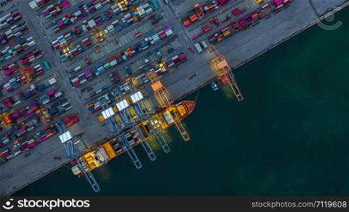 Container ship working at night, Business import export logistic and transportation of International by container ship in the open sea, Aerial view container ship loading and unloading at night.