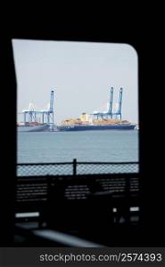 Container ships docked at a commercial dock viewed through the window of a ship, Patriot&acute;s Point, Charleston Harbor, Charleston, South Carolina, USA