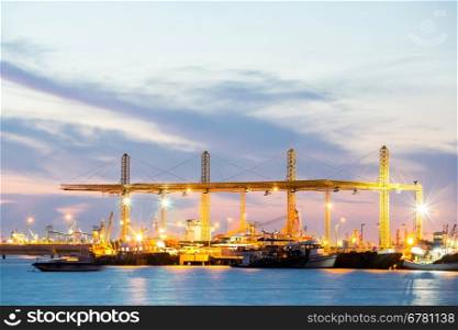 Container stacks and crane in shipyard at dusk for cargo Goods and Logistic background