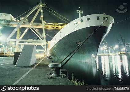 Containership being loaded in dock at night