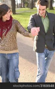 Contemporary Couple Walking In The Park And Holding Hands