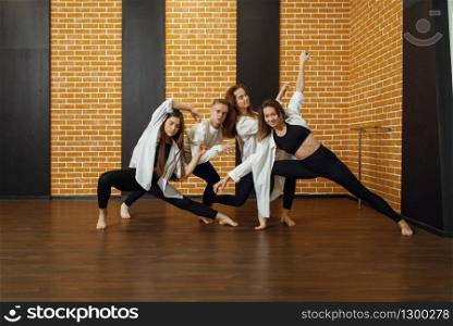 Contemporary dance group poses in studio. Female and male dancers training in class, modern grace dancing. Contemporary dance group poses in studio