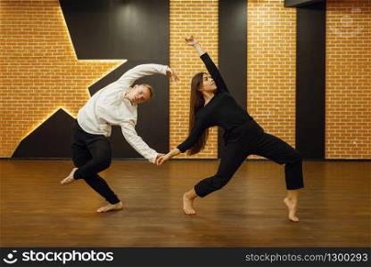 Contemporary dance partners, couple posing in studio. Male and female dancers on workout in class, modern dancing performing, stretching exercise