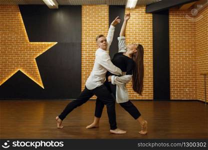 Contemporary dance performers, couple training in studio. Male and female dancers on workout in class, modern dancing, stretching exercise. Contemporary dance couple training in studio
