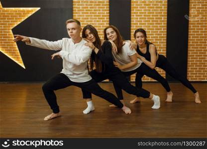 Contemporary dance performers in studio, snapshot in action. Female and male dancers training in class, modern grace dancing, stretching exercise, aerobic. Contemporary dance performers, snapshot in action