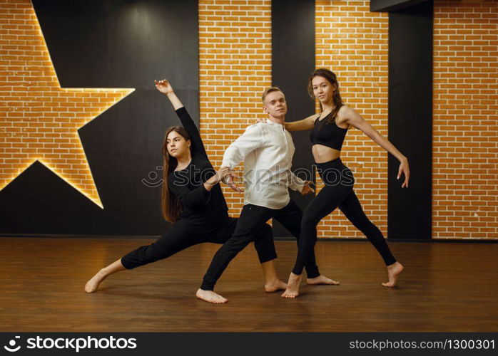 Contemporary dance performers posing in studio. Dancers training in class, modern ballet, elegance dancing, stretching exercise. Contemporary dance performers posing in studio