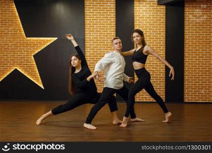 Contemporary dance performers posing in studio. Dancers training in class, modern ballet, elegance dancing, stretching exercise. Contemporary dance performers posing in studio
