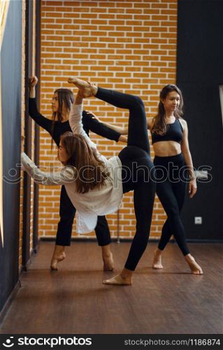 Contemporary dance performers, women on workout in studio. Dancers training in class, modern ballet, elegance dancing, stretching exercise. Contemporary dance performers, stretching exercise