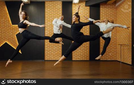 Contemporary dance studio, performers in jump. Female and male dancers training in class, modern grace dancing, stretching exercise, acrobats