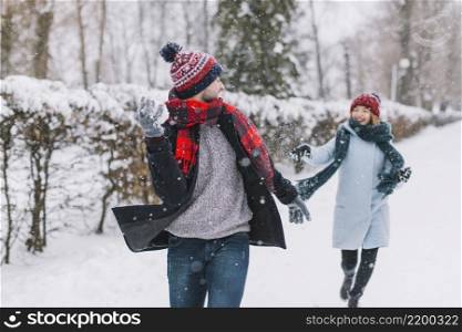 content couple playing snowballs park