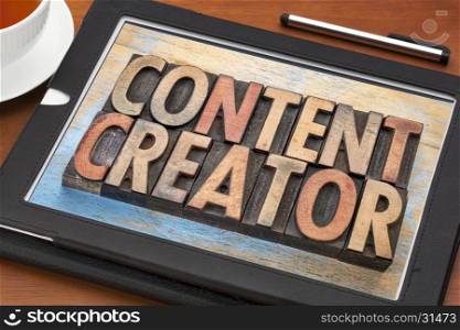 content creator - word abstract in vintage letterpress wood type printing blocks on a digital tablet