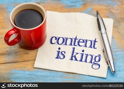 content is king - writing, blogging and publishing concept - handwriting on a napkin with a cup of coffee