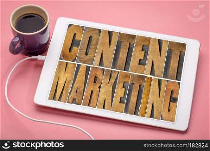 content marketing word abstract on tablet. content marketing - word abstract in vintage letterpress wood type printing blocks on a digital tablet with a cup of coffee
