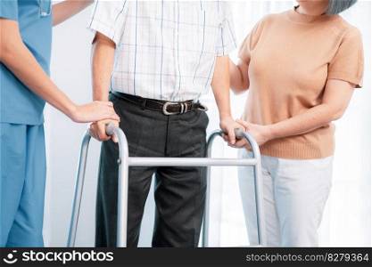 Contented senior man was helped on folding walking by his wife and caregiver. Recuperation for elderly, seniors care, nursing home.. Contented senior man was helped on folding walker by his wife and caregiver.