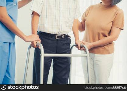 Contented senior man was helped on folding walking by his wife and caregiver. Recuperation for elderly, seniors care, nursing home.. Contented senior man was helped on folding walker by his wife and caregiver.