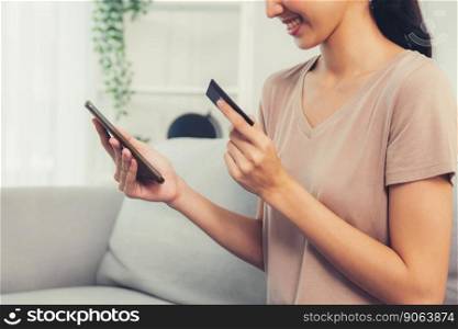 Contented young woman eagerly makes an online purchase using her smartphone. E-commerce business, online purchasing.. Contented young woman eagerly makes an online purchase using her smartphone.