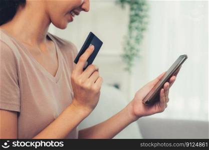 Contented young woman eagerly makes an online purchase using her smartphone. E-commerce business, online purchasing.. Contented young woman eagerly makes an online purchase using her smartphone.
