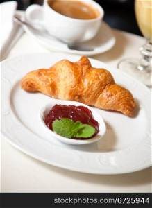 Continental breakfast. Freshly baked croissants with jam, strawberries, coffee and orange juice.