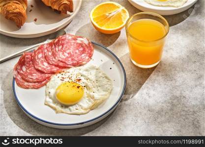 Continental breakfast. Fried eggs and sausage with croissants and orange juice