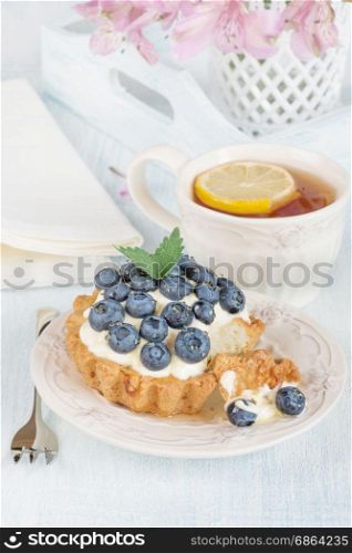 Continental breakfast with cheesecake, fresh berries and tea with lemon