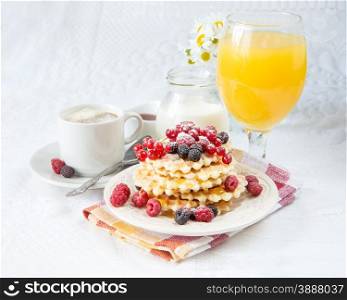 Continental breakfast with coffee, sweet waffles, fresh berries and orange juice