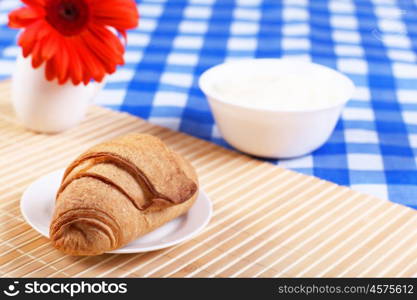 Continental breakfast with croisant on white plate