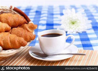 Continental breakfast with croissant and black coffee