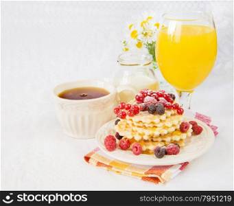 Continental breakfast with sweet waffles, fresh berries and orange juice