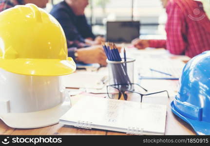 Contractor construction engineer meeting together on architect table at construction site. Business man and engineer manager discussing with foreman team builder blueprint using measure tape.