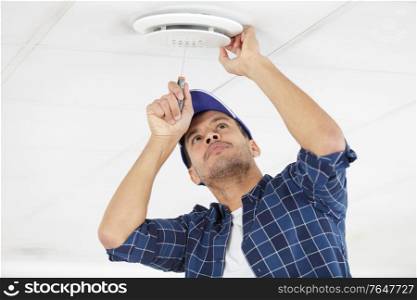 contractor fitting ceiling vent using screwdriver