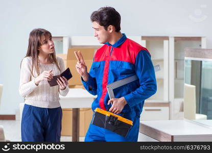 Contractor repairman assembling furniture under woman supervision