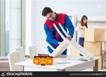 Contractor repairman assembling furniture under woman supervision