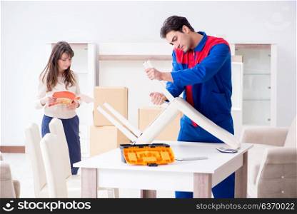 Contractor repairman assembling furniture under woman supervision. Contractor repairman assembling furniture under woman supervisio