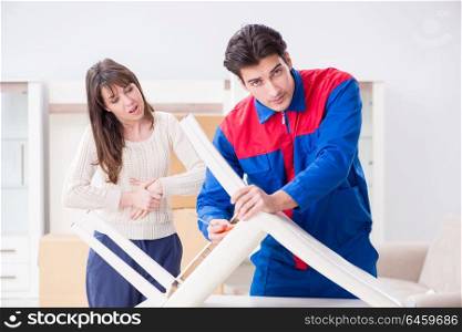 Contractor repairman assembling furniture under woman supervision. Contractor repairman assembling furniture under woman supervisio