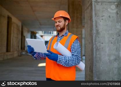 Contractor using digital tablet for connection with engineer. Builder reporting having video call. Contractor using digital tablet at construction site