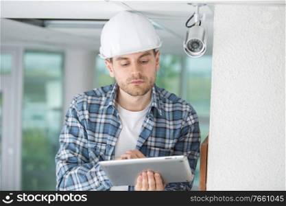 contractor using tablet by security camera