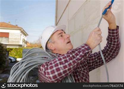 Contractor with reel of cable on shoulder