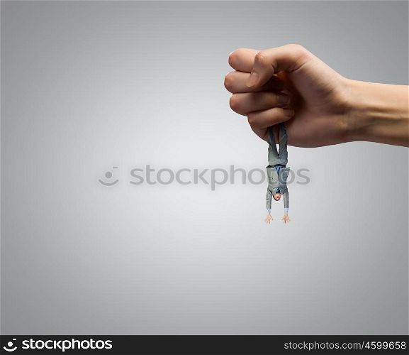Control and power. Close up of big human hand catching businessman
