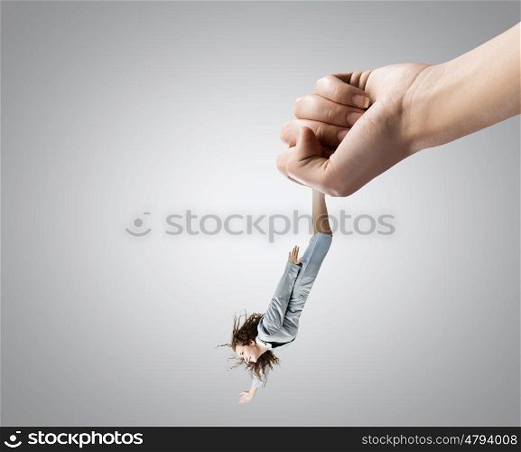 Control and power. Close up of big human hand catching businesswoman
