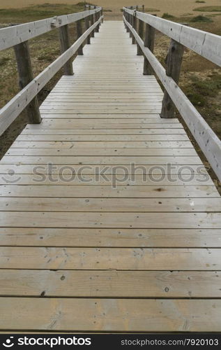 Converging wooden bridge with handrails. Chesil Beach, Weymouth, Dorset, England, United Kingdom.